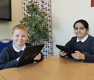 Grange Community Primary School - 2 pupils working on iPads photo